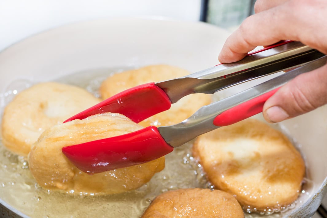 Frying donuts in hot oil. Homemade domestic donuts preparing in hot oil